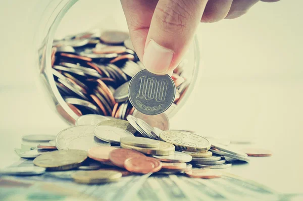 Hand picking up 100 Japanese yen (JPY) coin out of multi currencies — Stok fotoğraf