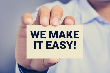 Kolaylaştırabiliriz! Bir adam tarafından gösterilen kartta mesaj