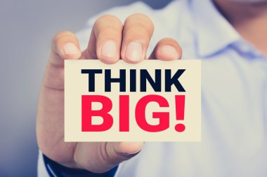 Büyük düşün! bir adam tarafından gösterilen kartındaki mesaj