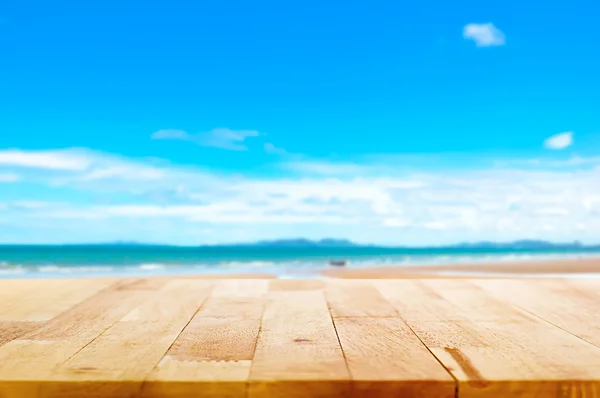 Houten tafelblad op strand achtergrond wazig — Stockfoto