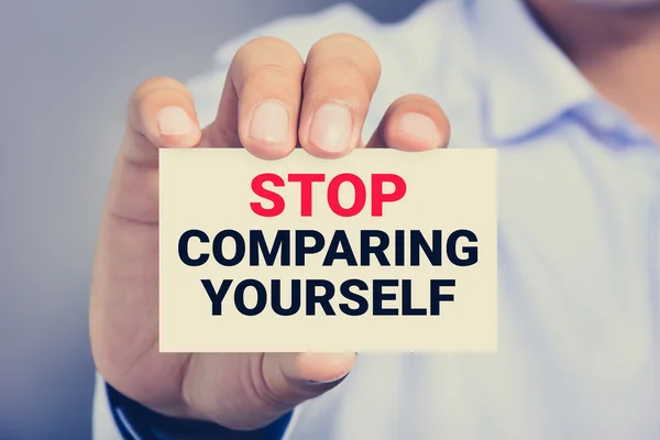 STOP COMPARING YOURSELF, mensagem no cartão mostrado por um homem — Fotografia de Stock