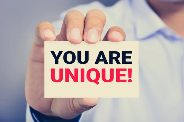 YOU ARE UNIQUE ! message on the card shown by a man hand — Stock Photo, Image