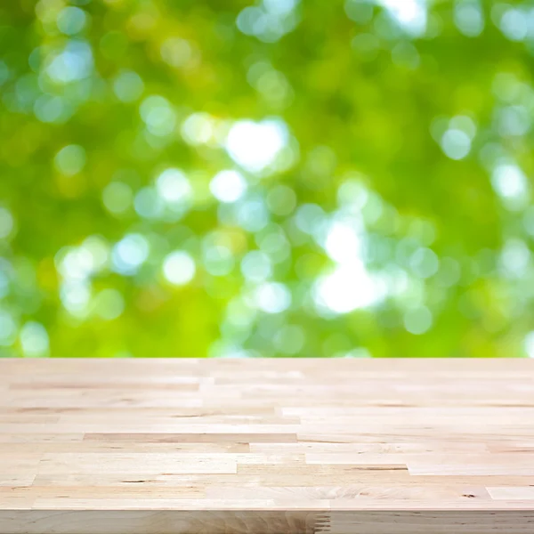 Dřevo stolu na abstraktní pozadí zelené přirozený bokeh — Stock fotografie