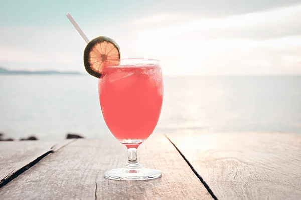 Cocktail drink on wooden table with sea & sky background — Stock Photo, Image