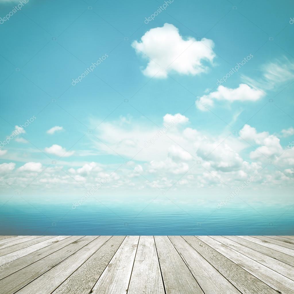 Wood table top on blue sea and sky background, vintage tone image