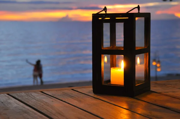 Svíčka Lucerna s pár na pláži jako pozadí — Stock fotografie