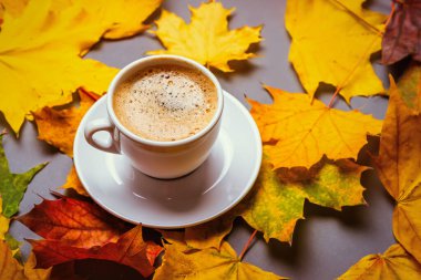 Sonbahar yapraklarının arka planında bir fincanda kahve.