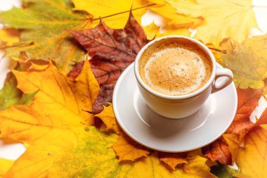 Sonbahar yapraklarının arka planında bir fincanda kahve.