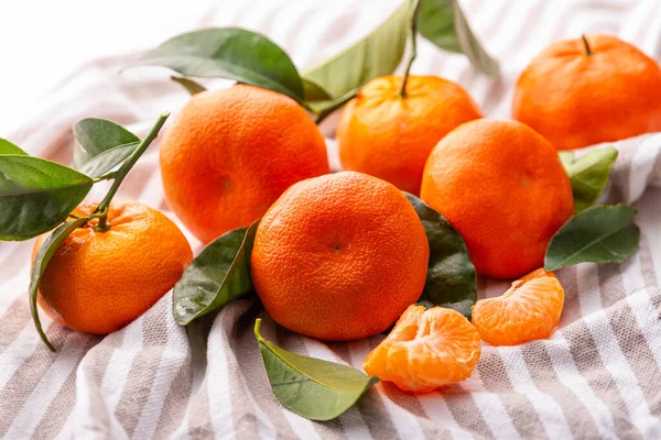 Mandarinen Mit Blättern Liegen Auf Einem Gestreiften Handtuch — Stockfoto