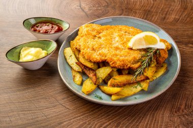 Mavi tabakta kızarmış patatesli şnitzel. 