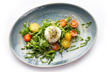 Mozzarella topu ve mavi tabakta sebze salatası.