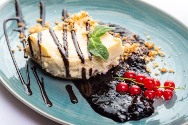 Kırmızı frenk üzümü ve nane şekeriyle süslenmiş kek parçaları.