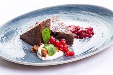 Kırmızı frenk üzümü ve nane şekeriyle süslenmiş çikolata parçaları.