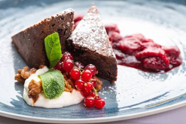 Kırmızı frenk üzümü ve nane şekeriyle süslenmiş çikolata parçaları.