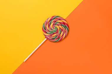 Sarı ve turuncu zemin üzerinde yuvarlak renkli lolipop ve kopya için boşluk