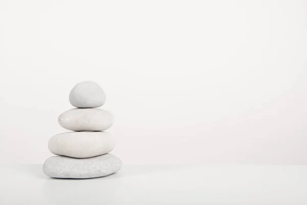 Stack of  white zen stones on a white background with copy space
