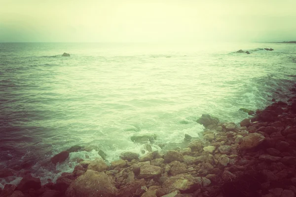 Скелястий берег і бурхливому морі в зелений світіння — стокове фото