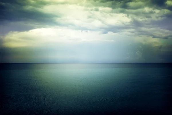 Luce nel cielo sopra il mare oscuro e cupo — Foto Stock