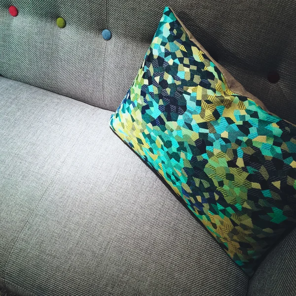 Decoratieve groene en gele kussen op een sofa — Stockfoto