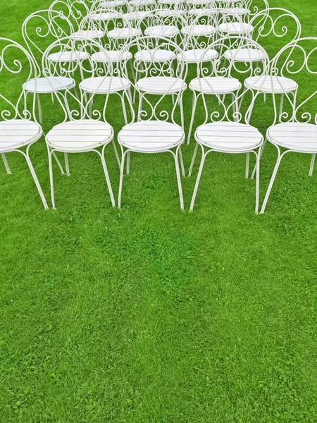 Green lawn with empty white chairs — Stock Photo, Image