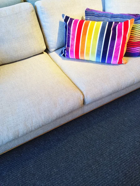 Sofa with bright rainbow striped cushions — Stock Photo, Image