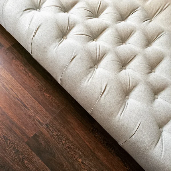 暗い木製の床の豪華な白いオットマン — ストック写真