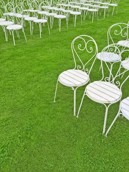 Empty white chairs on the green lawn — Stock Photo, Image