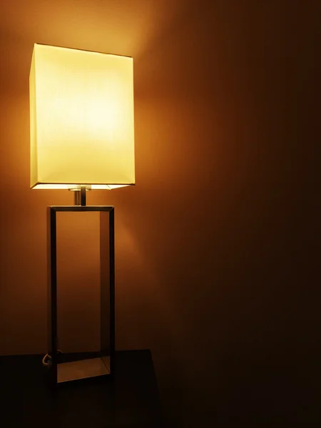 Illuminated table lamp in a dark room — Stock Photo, Image