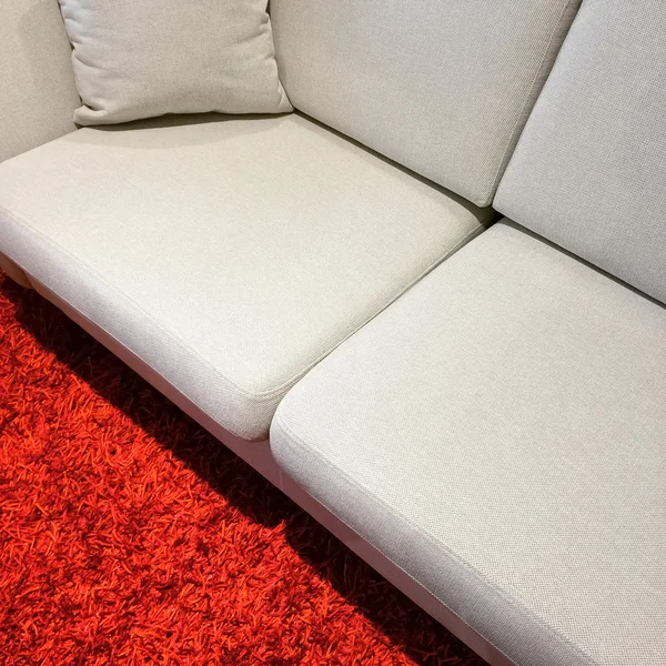 Weißes Sofa auf rotem Teppich — Stockfoto