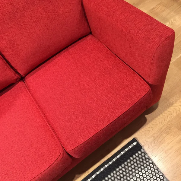 Sofá clásico rojo sobre suelo de madera — Foto de Stock