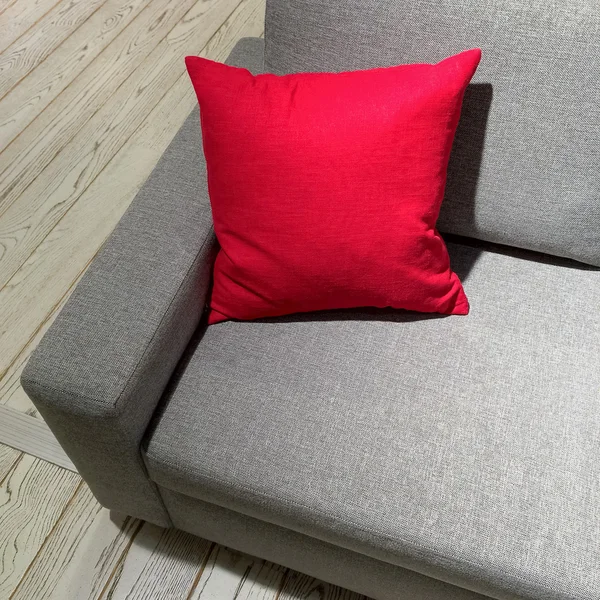 Klassisches graues Sofa mit leuchtend rotem Kissen — Stockfoto