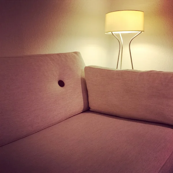 Cómodo sofá de tela y acogedora lámpara —  Fotos de Stock