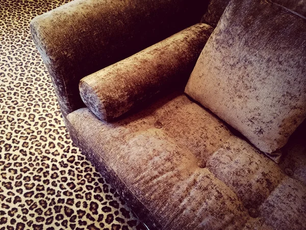 Sofá de veludo no tapete de leopardo — Fotografia de Stock