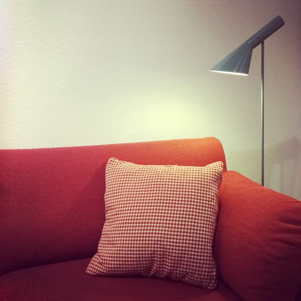 Sofa merah dengan bantal dan lampu — Stok Foto
