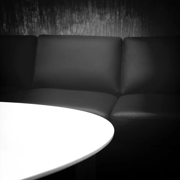 Schwarzes Ledersofa und weißer Tisch — Stockfoto