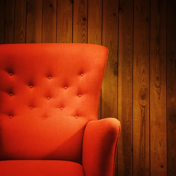 Klasické červené křeslo dřevěné zdi — Stock fotografie