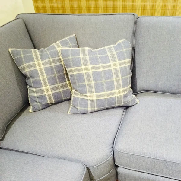 Checked cushions on gray sofa — Stock Photo, Image