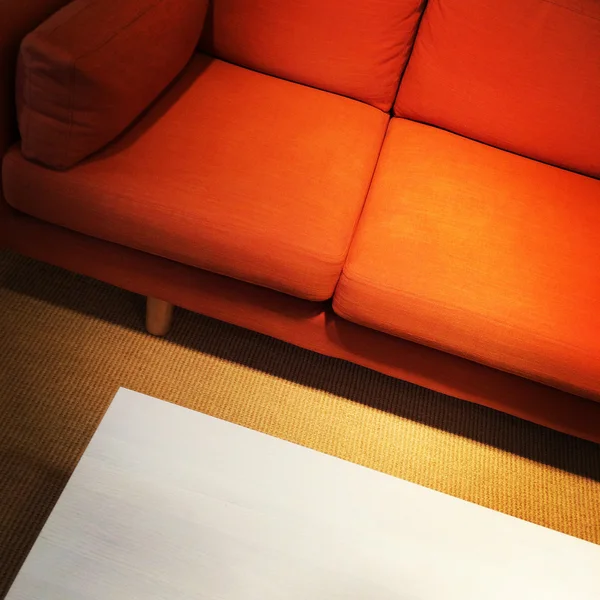 Sofá naranja brillante y mesa de café — Foto de Stock
