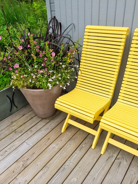 Casa exterior decorado com cadeiras amarelas e flores — Fotografia de Stock