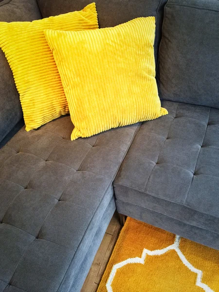 Sarı yastıkları ile gri kanepe — Stok fotoğraf