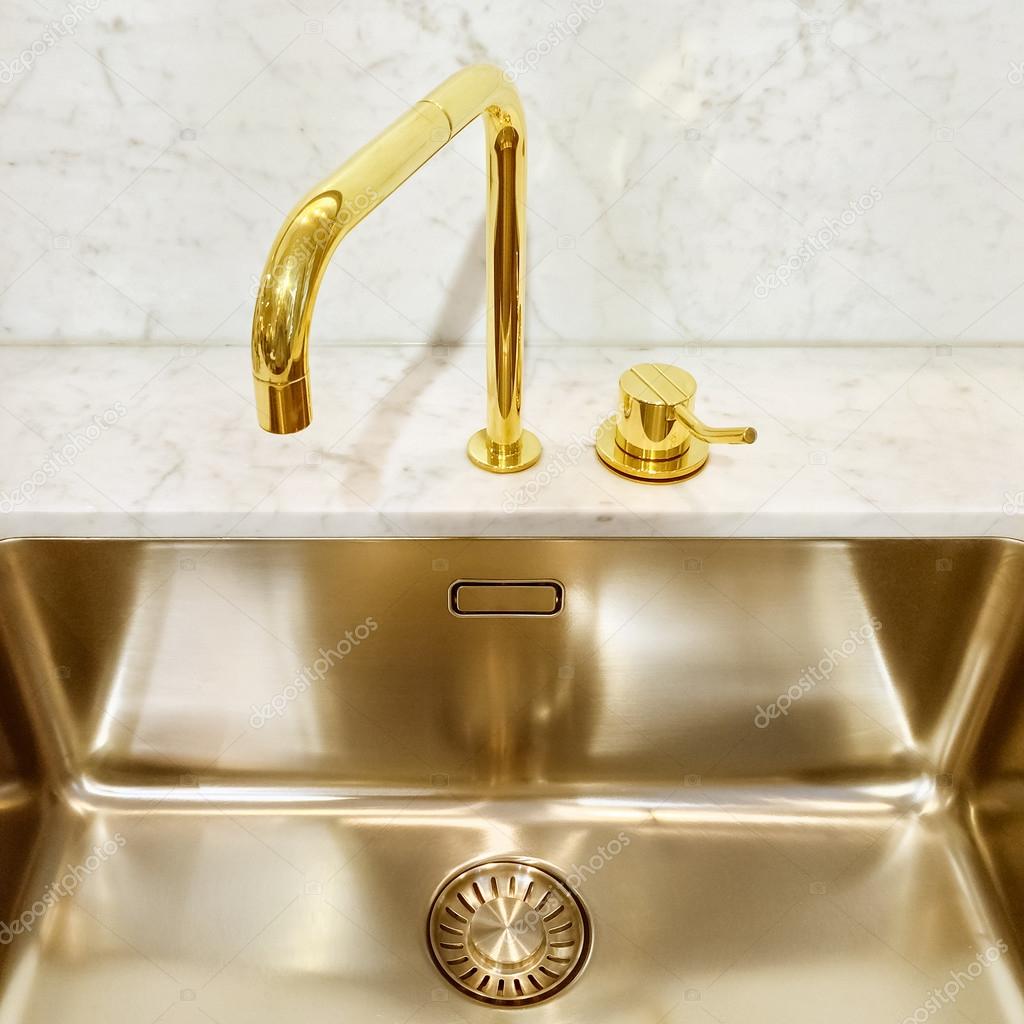 Kitchen sink with golden faucet
