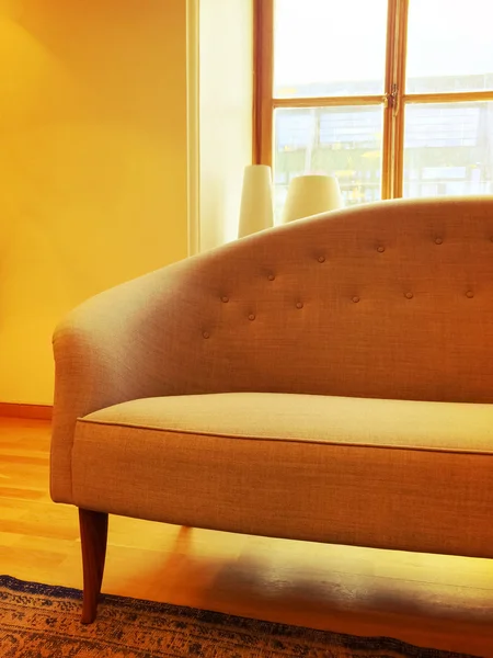 Sofá elegante em uma sala iluminada pelo sol com grande janela — Fotografia de Stock