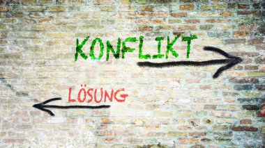 Almanca 'nın iki farklı yönünü gösteren işaret direği olan bir resim. Bir yön çatışmaya işaret ediyor, diğeri çözüme..