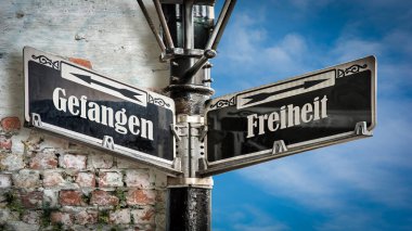 Almanca 'nın iki farklı yönünü gösteren işaret direği olan bir resim. Bir yön özgürlüğü, diğeri esiri işaret ediyor..