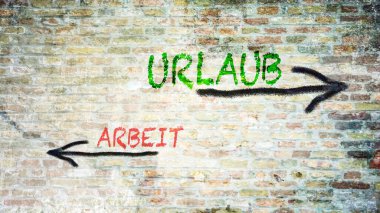 Almanca 'nın iki farklı yönünü gösteren işaret direği olan bir resim. Bir yön tatile işaret ediyor, diğeri işe işaret ediyor..