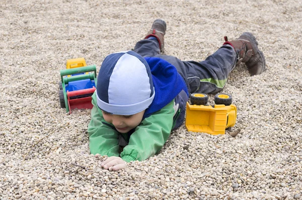 Kind spielt auf Spielplatz mit Steinen — Stockfoto