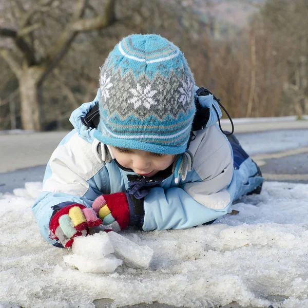 Niño jugando con nieve y hielo —  Fotos de Stock