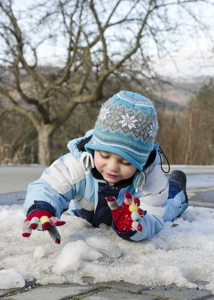 Niño jugando con nieve y hielo — Foto de Stock