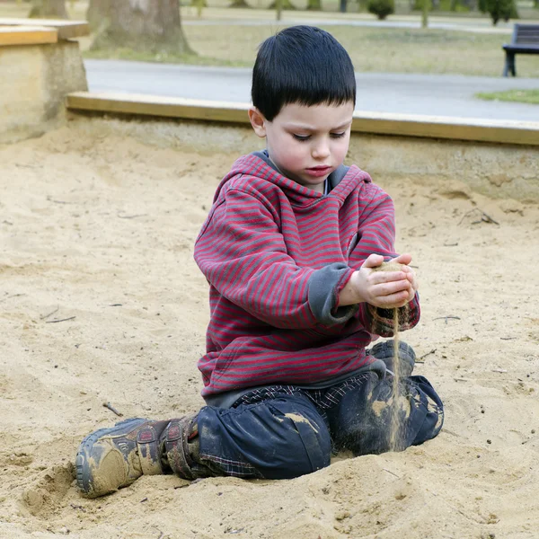 Criança em playground brincando em poço de areia — Fotografia de Stock