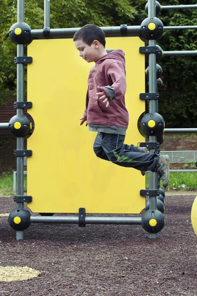 Niño saltando en el patio de recreo — Foto de Stock